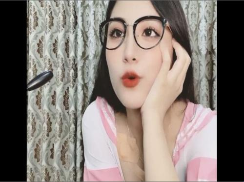 Dia memakai cermin mata dan menampakkan payudaranya yang besar